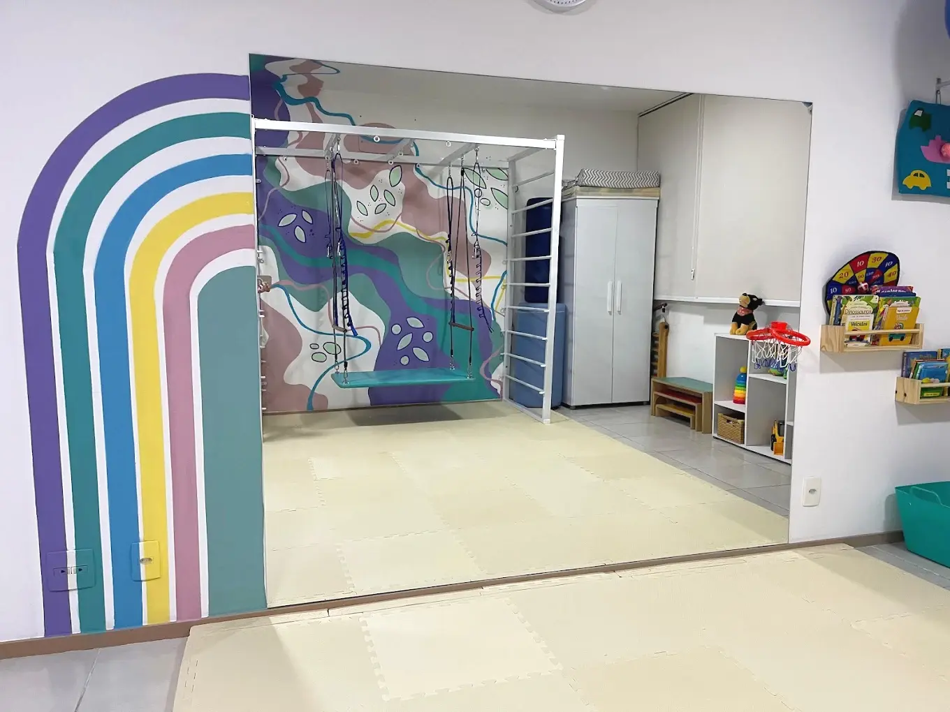 Área de fisioterapia infantil com estrutura de movimento e brinquedos